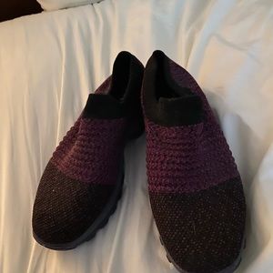 Purple and black sketchers shoes.